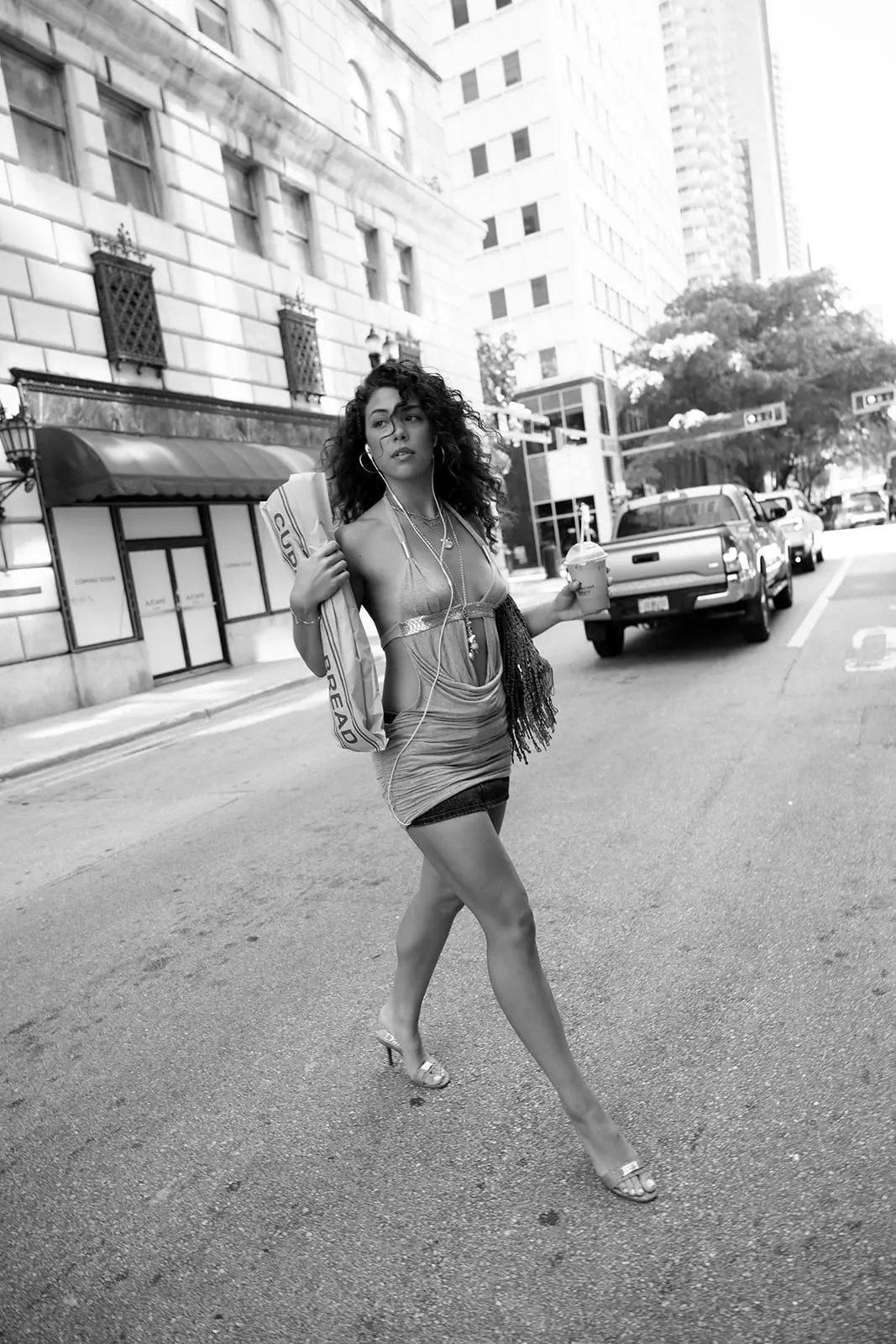 Black-and-white street shot: Bella Valdes mid-stride in downtown Miami, bag over her shoulder.
